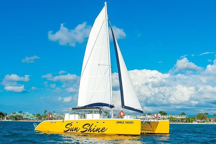 Cat Cruise sunset catamaran with tropical water and people swimming